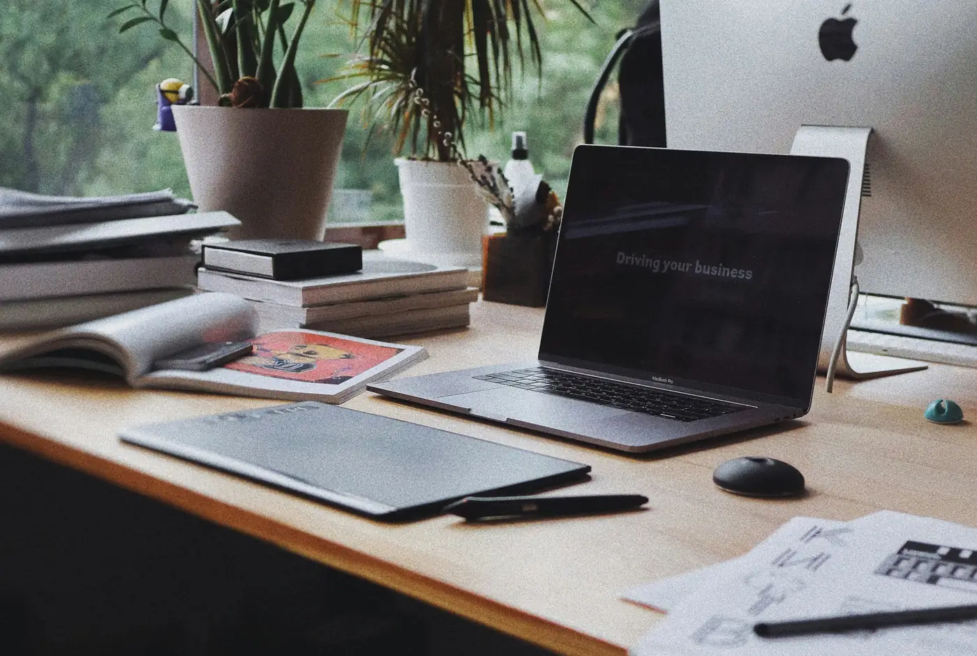 Desk by a window with a laptop, open notebooks and documents, where the legal checks before a property purchase in Mallorca are reviewed